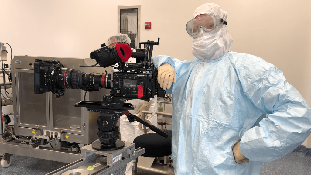 Evan Luzi suited up in PPE to film in a vaccine laboratory