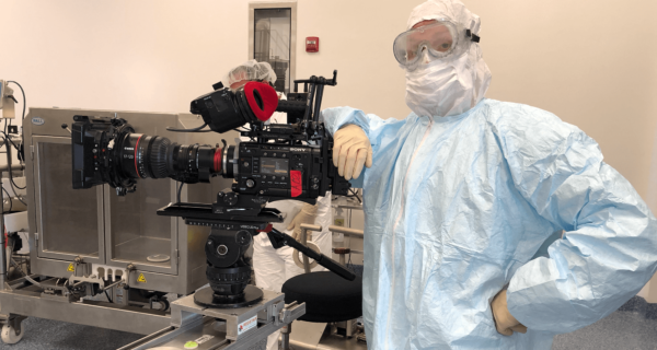 Evan Luzi suited up in PPE to film in a vaccine laboratory